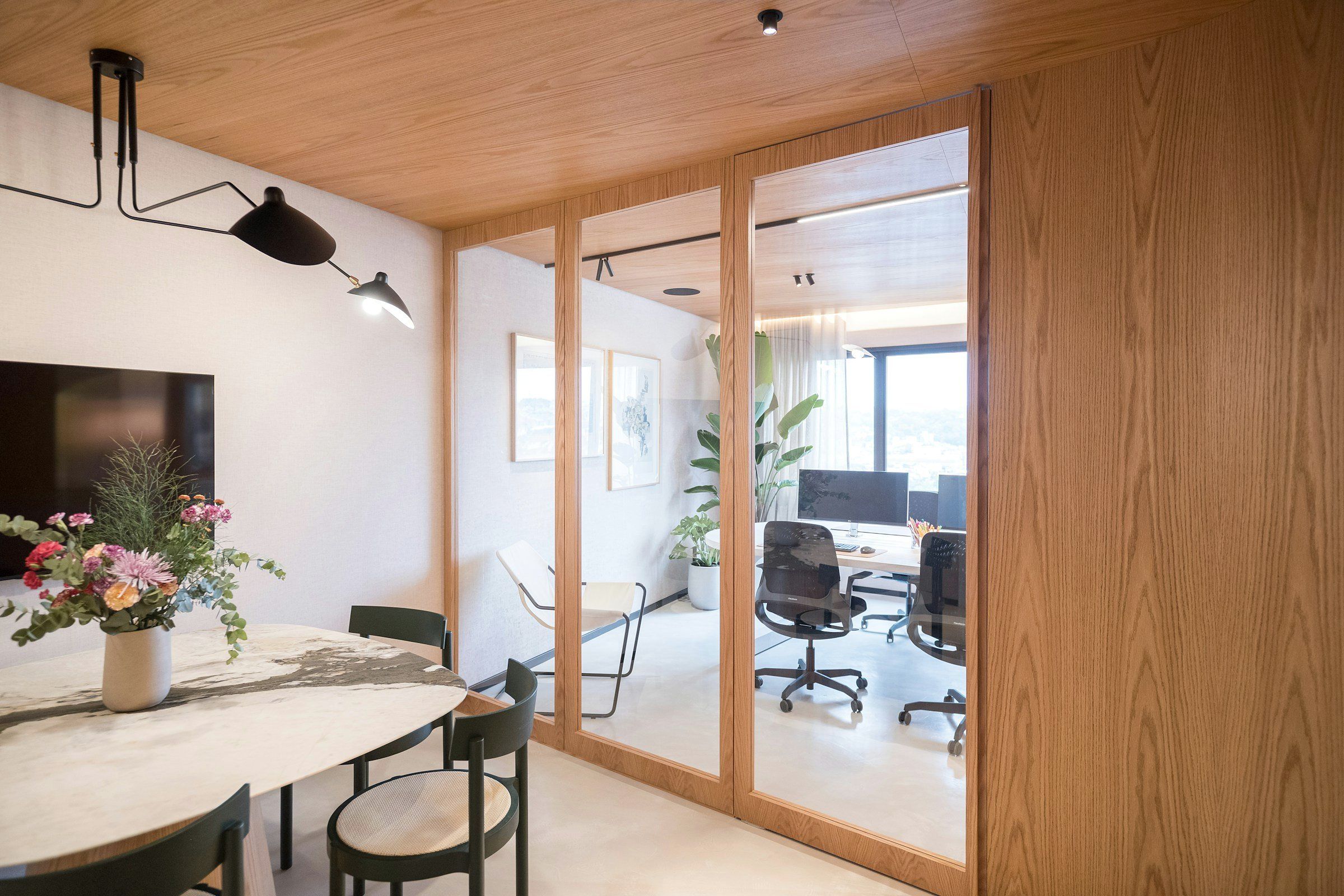 Besprechungsraum mit Glaswand und Blick in ein Büro